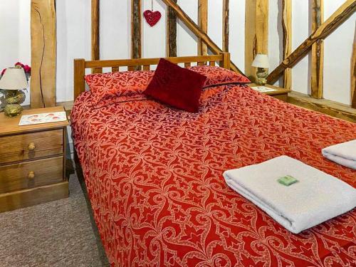 a red bed with two pillows on top of it at The Lodge - Uk44556 in Plaistow