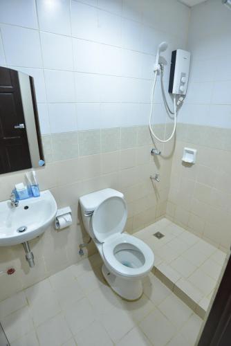a bathroom with a toilet and a sink at Amax Inn Makati in Manila