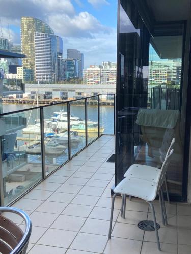 a white chair on a balcony with a view of a harbor at AKOM AT Docklands in Melbourne