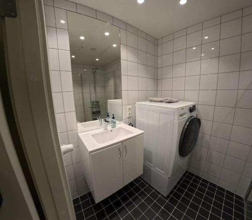 een badkamer met een wastafel en een wasmachine bij Apartment in city center in Alta