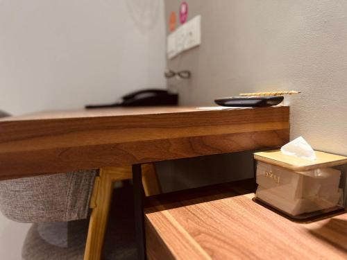 a wooden desk with a remote control on top of it at oxy suites 1-03 at Shop House Meisterstadt Pollux Habibie in Batam Center