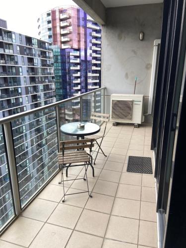 a balcony with a table and chairs and buildings at AKOM AT Docklands in Melbourne
