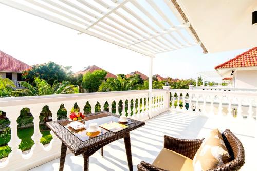 a patio with a table and chairs on a balcony at Mercury Phu Quoc Resort & Villas in Phu Quoc