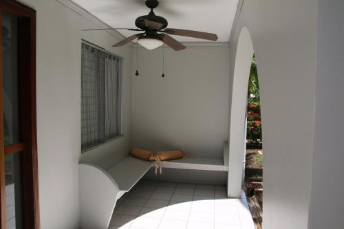 a porch with a bench and a ceiling fan at Family 2bd apt near Quepos/Manuel Antonio in Quepos