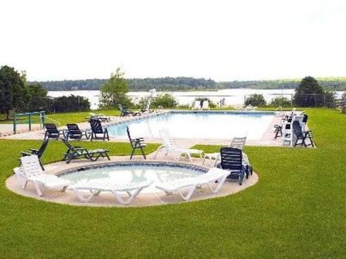 uma grande piscina com cadeiras ao redor em Pocono Vacation Retreat em Albrightsville