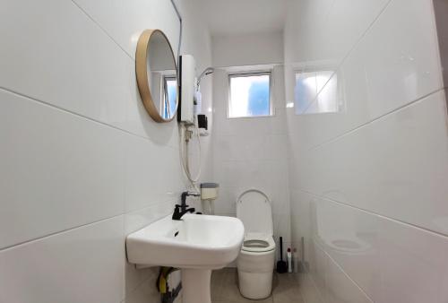 a white bathroom with a sink and a toilet at 3 mins to Garden City & Kubota Jln Apas Homestay in Tawau