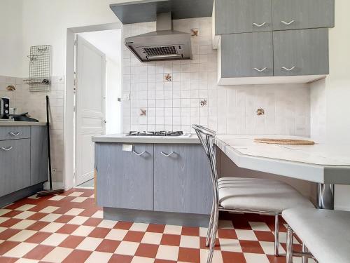 - une cuisine avec un sol en damier et un comptoir dans l'établissement Appartement 3 pièces à 150m de la mer avec cour fermée et terrasse ensoléillée - FR-1-746-12, à Courseulles-sur-Mer