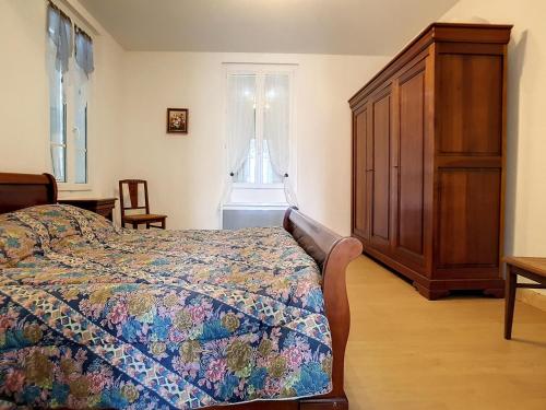 une chambre avec un lit et une armoire en bois dans l'établissement Appartement 3 pièces à 150m de la mer avec cour fermée et terrasse ensoléillée - FR-1-746-12, à Courseulles-sur-Mer
