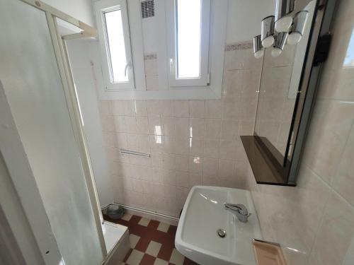 une salle de bain blanche avec un lavabo et un miroir dans l'établissement Appartement 3 pièces à 150m de la mer avec cour fermée et terrasse ensoléillée - FR-1-746-12, à Courseulles-sur-Mer