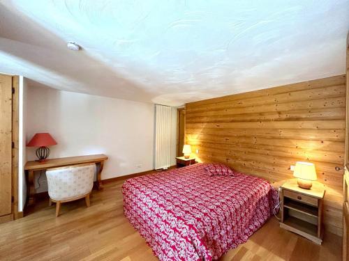 a bedroom with a red bed and a wooden wall at Appartement La Clusaz, 4 pièces, 8 personnes - FR-1-437-104 in La Clusaz