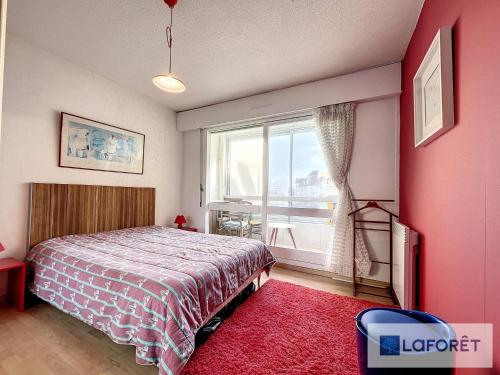 une chambre avec un lit et une grande fenêtre dans l'établissement Beau T2 face à Juno Beach avec parking privé - FR-1-746-7, à Courseulles-sur-Mer