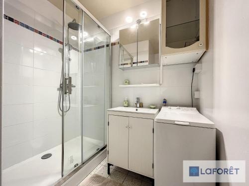 une salle de bain blanche avec une douche et un lavabo dans l'établissement Beau T2 face à Juno Beach avec parking privé - FR-1-746-7, à Courseulles-sur-Mer