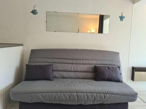 ein Sofa mit zwei Kissen in einem Zimmer in der Unterkunft Appartement Cap d'Agde, 1 pièce, 2 personnes - FR-1-249-398 in Cap d'Agde