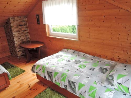 a bedroom with a bed and a table and a window at Holiday house in Mi dzyzdroje for 5 people in Międzyzdroje
