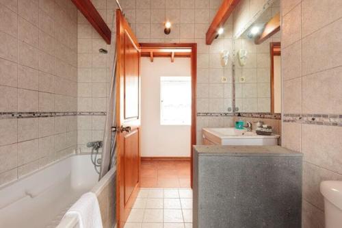 y baño con bañera, aseo y lavamanos. en holiday home, Praínha de Baixo, en Prainha de Baixo