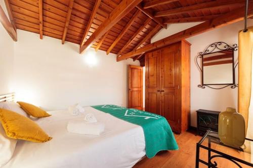 1 dormitorio con 1 cama blanca grande y espejo en holiday home, Praínha de Baixo, en Prainha de Baixo