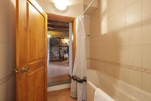 La salle de bains est pourvue d'une baignoire et d'un rideau de douche. dans l'établissement holiday home, Praínha de Baixo, Pico, Azores, à Prainha de Baixo