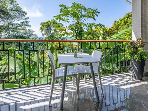 a white table and two chairs on a balcony at Maison D'Aaryan in Anse aux Pins