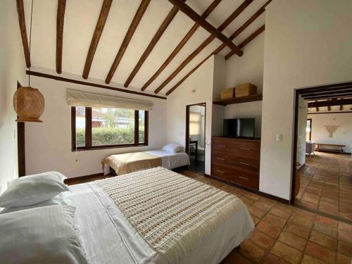 a bedroom with two beds and a large window at CASAMIGOS in Villa de Leyva