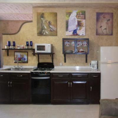 a kitchen with a stove and a sink and a microwave at Casita Montana Hotel in Ajijic