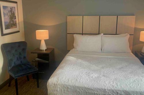 a bedroom with a large bed and a chair at Ultimate Escape/Free Parking in Houston