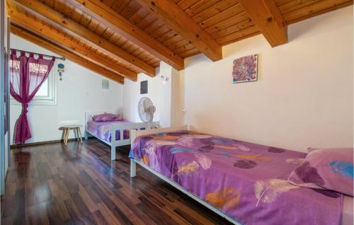 2 letti in una camera con soffitti in legno di Gorgeous Home In Krnica With Kitchen a Krnica