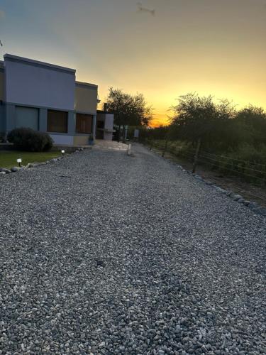 una entrada de grava frente a una casa al atardecer en Villa Bonita Cabañas en Merlo