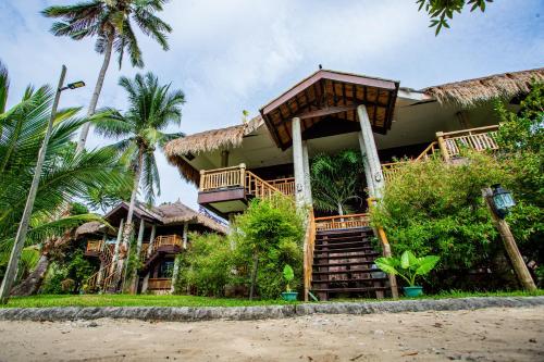 a resort on the beach with palm trees at Club Agutaya in San Vicente