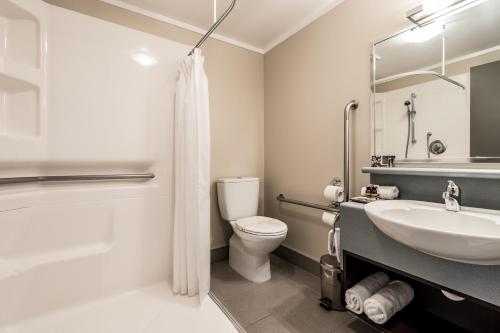 a bathroom with a sink and a toilet and a shower at Sails on the Lake in Taupo