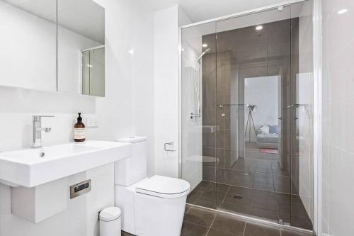 La salle de bains est pourvue de toilettes, d'un lavabo et d'une douche. dans l'établissement Exceptional Beach views - Luxury apartment, à Newcastle