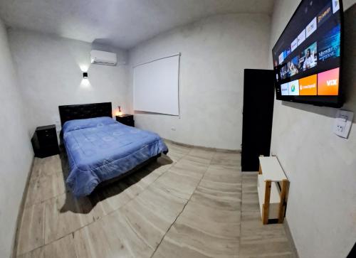 sypialnia z łóżkiem i telewizorem z płaskim ekranem w obiekcie Casa Valle Viejo w mieście San Fernando del Valle de Catamarca