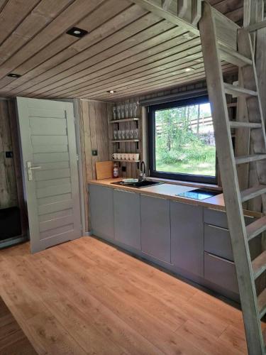 a kitchen with a large window and a kitchen counter at Hytte Narie 2 in Bogaczewo