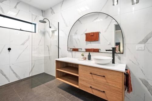 甘比爾山的住宿－City Edge Apartment 1 (Wheelchair Accessible)，一间带水槽和镜子的浴室
