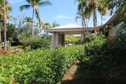 a garden in front of a house with palm trees at Family 2bd apt near Quepos/Manuel Antonio in Quepos