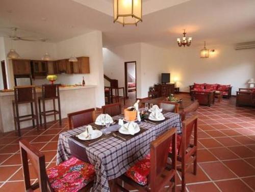 a living room with a table and chairs and a kitchen at Full Moon Village Resort in Mui Ne