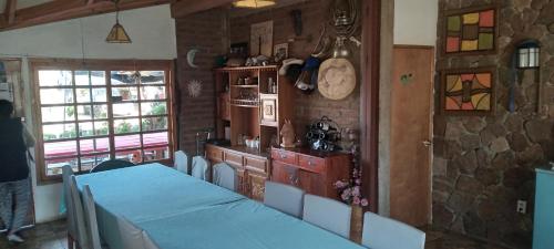 una sala da pranzo con tavolo e orologio sul muro di Alojamiento Rural Polita, Agroturismo y Patrimonial a Petorca