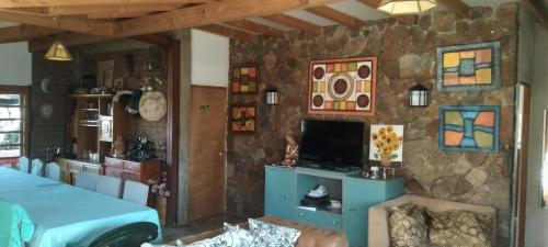 um quarto com uma televisão e uma parede de pedra em Alojamiento Rural Polita, Agroturismo y Patrimonial em Petorca