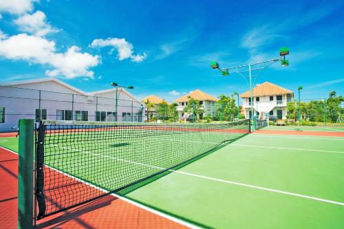 a tennis court with a net in front of a building at Mercury Phu Quoc Resort & Villas in Phu Quoc