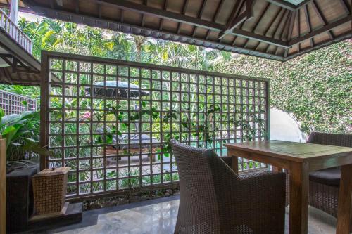 a patio with a table and chairs and a fence at KajaNe Mua at Ubud Bali in Ubud