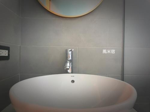 lavabo blanco en el baño con espejo en 鳳米宿Roomi house3, en Tainan