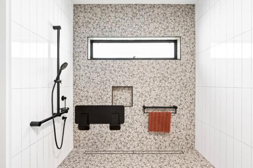 a bathroom with a shower with a sink and a window at City Edge 2 Apartment - Wheelchair Accessible in Mount Gambier