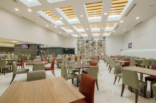 a dining room with tables and chairs in a room at Real Inn Tijuana by Camino Real Hoteles in Tijuana
