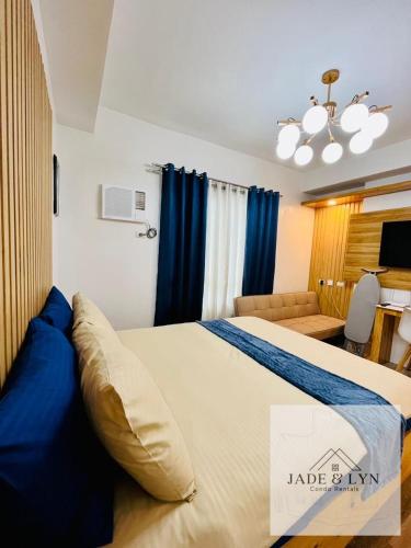 - une chambre avec un grand lit et des rideaux bleus dans l'établissement Your home away from home, at the heart of Bacolod., à Bacolod