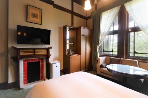 a bedroom with a bed and a fireplace and a tv at Nara Hotel in Nara