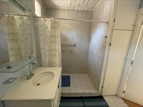 La salle de bains est pourvue d'un lavabo et d'une douche. dans l'établissement Casita Montana Hotel, à Ajijic