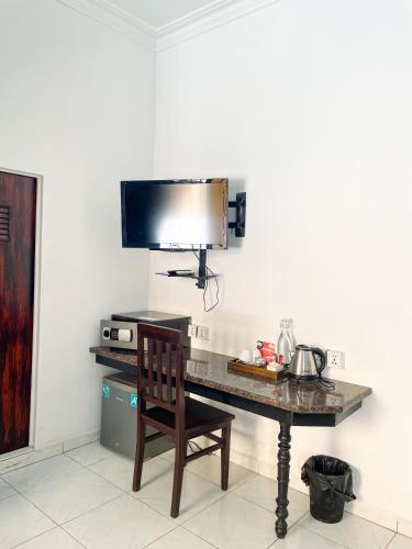 a desk with a chair and a television on a wall at Birdcage Boutique in Phnom Penh