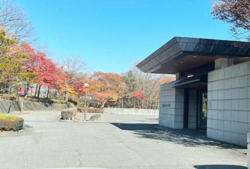 a building in a park with fall foliage at 那須 にごり湯の大浴場露天風呂があるホテルコンドミニアム in Nasu-yumoto