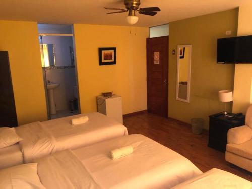 Habitación de hotel con 2 camas y sofá en Hotel Las Condes, en Trujillo