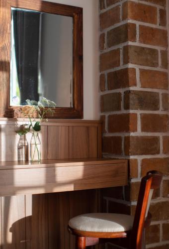 a wooden table with a mirror on a brick wall at Le Soleil Boutique Hotel in Da Lat