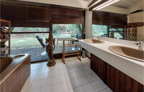 uma casa de banho com 2 lavatórios e uma grande janela em 4 Bedroom Beautiful Home In Mrignac em Mérignac